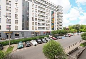 Een meerlaags gebouw met een parkeerplaats ervoor.