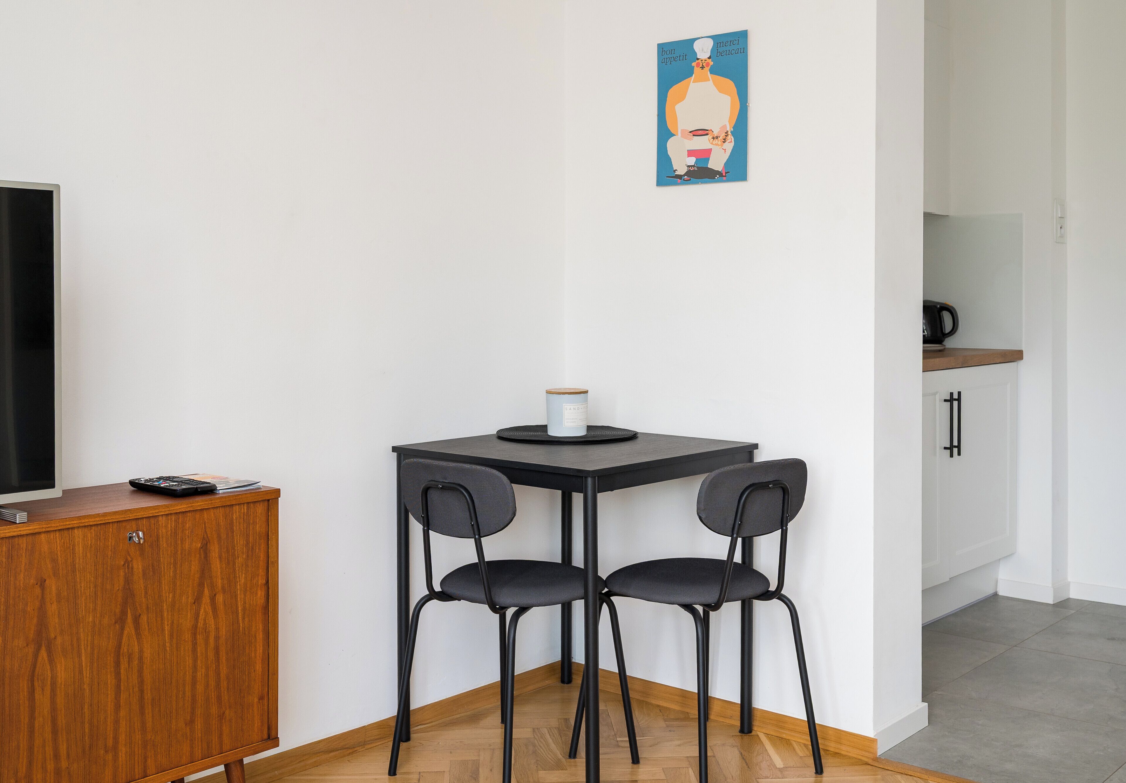 Une petite cuisine équipée d’une machine à café, d’une télévision et d’un placard.