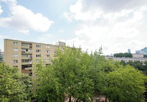 Ein mehrstöckiges Gebäude mit Balkonen, umgeben von üppigem Grün.