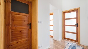 A hallway with wooden doors, a light-colored floor, and a rug. - Warecka City Center Living Apartment (Warszawa)