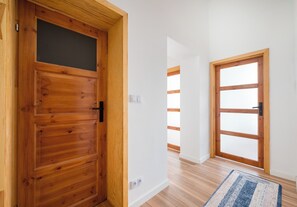 A hallway with wooden doors, a light-colored floor, and a rug. - Warecka City Center Living Apartment (Warszawa)