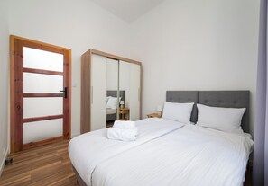 A bedroom with a bed, a wardrobe, a nightstand, and a mirror. - Warecka City Center Living Apartment (Warszawa)