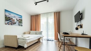Ein modernes Zimmer mit einem Bett, einem Esstisch und einem Fernseher.