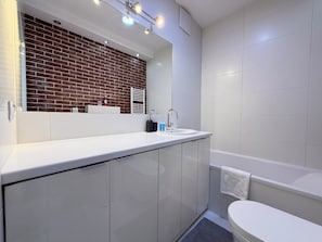 A modern bathroom with a white sink, mirror, and toilet. - Zakładowa Modern Living Studio (Wrocław)
