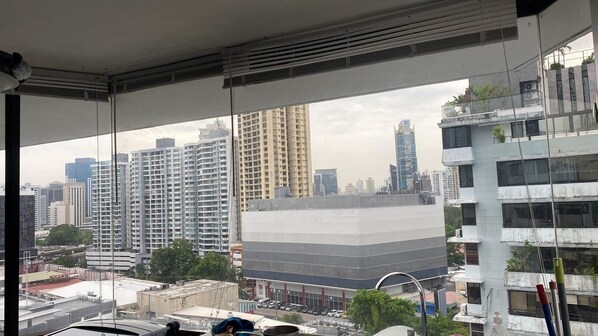 A view from a window with a cityscape, including high-rise buildings and a parking lot.