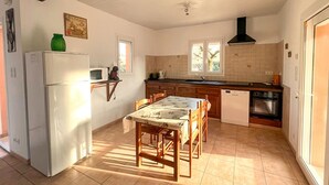 Una cucina compatta con frigorifero, microonde, lavello e piano cottura.