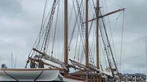 Un gran barco velero amarrado en un puerto deportivo.