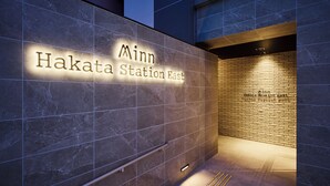 A sign for 'Minn Hakata Station East' with a modern design, featuring a combination of marble and brick textures. - Minn Hakata Station East (Fukuoka)