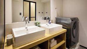 A bathroom with two sinks, a mirror, a plant, and a washing machine. - Minn Hakata Station East (Fukuoka)