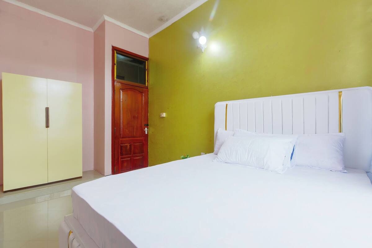 A bedroom with a bed, a wardrobe, and a door.