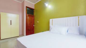 A bedroom with a bed, a wardrobe, and a door.