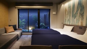 A hotel room with a bed, a sofa, and a view of greenery through a window. - SHIFTHOTEL AZABU ROPPONGI (Minato City)