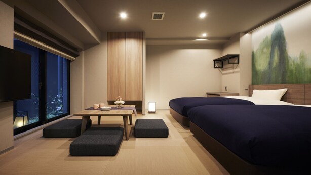 A modern hotel room with a large bed, a desk with a chair, a small table with a vase, and a TV mounted on the wall. - SHIFTHOTEL AZABU ROPPONGI (Minato City)