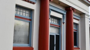 A building with three columns, a door, and windows with blinds. - The Merredin Treasury (Merredin)