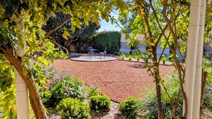 A garden with a circular seating area, a pergola, and various plants. - The Merredin Treasury (Merredin)