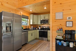 A compact kitchen with a refrigerator, microwave, and coffee maker. - Blue Sky Retreat.  Cozy 2 bedroom cabin in Red River Gorge. (Beattyville)