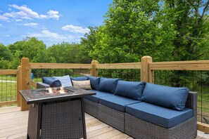 Een terras buiten met een ingebouwde bank en een vuurkorf.