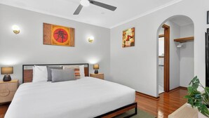 A modern hotel room with a large bed, two bedside tables with lamps, a ceiling fan, and artwork on the walls. - Hallett Horizon Explore Clifftops Coast and Trails (Hallett Cove)