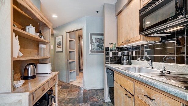 A kitchen with wooden cabinets, a microwave, a sink, and a toaster. - Beautiful Keystone Condo: Perfect Leaf Peeping! (Keystone)