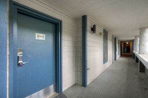 A hallway with a blue door marked '2905,' a light fixture, and a bench along the wall. - Perfect Keystone Ski Home: 2 Min Walk to Gondola! (Keystone)