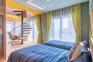 Una camera da letto con un letto, una sedia, una scala e una finestra con tende.