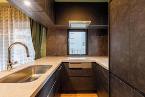 A modern kitchen with a built-in dishwasher, a stainless steel sink, and a window with a view of the city. - Spacious & Serene 84 ㎡ Retreat near Dotonbori, Kuromon Market & Shinsaibashi (大阪市)