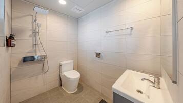 A modern bathroom with a toilet, shower, and sink.
