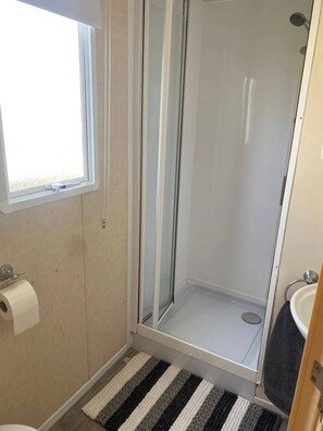 A bathroom with a shower, toilet, and sink. - Cabin Sleeps 6 with Parking near Beach (New Romney)