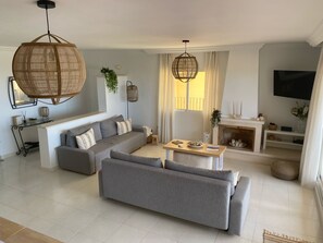Ein modernes Wohnzimmer mit einer Eckcouch, einem Couchtisch und einem Kamin.