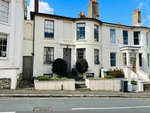 A corner building with a white facade, multiple windows, and a small front garden. - 2-bedroom Apartment Ryde Isle of Wight St9a (Ryde)