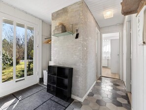 A hallway with a concrete wall, a black storage unit, and a patterned floor. - 4 Star Holiday Home in Gilleleje (Gilleleje)