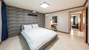 A bedroom with a bed, a desk, a chair, and a wardrobe.