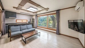 A modern living room with a sofa, coffee table, and a TV.