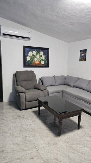 A living room with a gray sectional sofa, a gray recliner, and a glass coffee table. - "1200 m² Bacalar: Laguna a Pasos, Pet Friendly" (Xul-Ha)