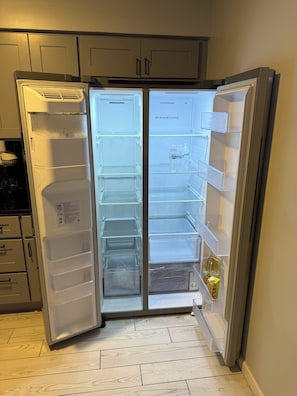 A modern kitchen with a built-in refrigerator, wooden flooring, and a small countertop area. - Modern 3BR Jersey City Retreat Near NYC & FIFA (Jersey City)