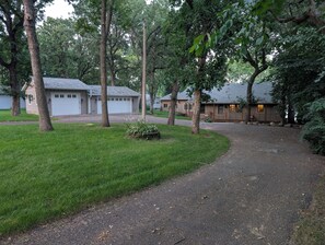 A residential area with houses, a driveway, and a well-maintained lawn.