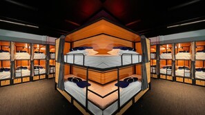 Habitación con literas múltiples, paredes de madera y techo espejado.