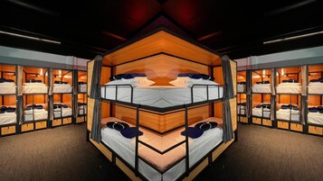 Habitación con literas múltiples, paredes de madera y techo espejado.