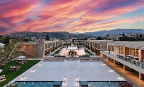 Un hotel con patio central, piscina al aire libre y vistas a la montaña.
