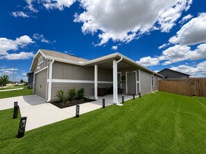 A single-story house with a covered front porch, a garage, and a well-maintained lawn. - Welcome to The Stagecoach Home – Your Texas Home Away From Home! (Rhome)