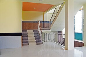Ein modernes Interieur mit einer Treppe, einem Empfangstresen und einer hellen Decke.