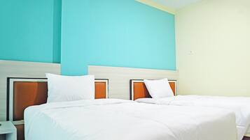 Een hotelkamer met twee bedden, een nachtkastje en een lichtgekleurde muur.
