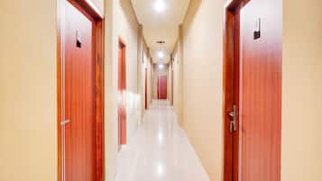 A corridor with wooden doors and a white floor.
