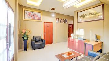 A modern hotel lobby with a reception desk, seating area, and artwork on the walls.