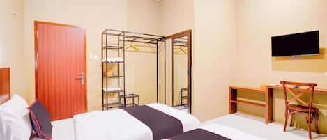 A hotel room with two beds, a desk, a chair, a TV, and a wardrobe.