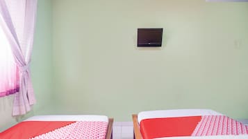 Quarto com duas camas, uma televisão na parede e uma cortina à esquerda.