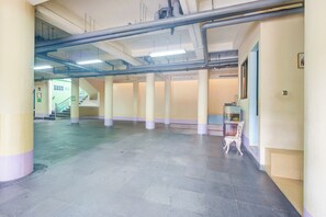 A spacious indoor area with a tiled floor, columns, and a staircase in the background. - Hotel O Tebet Near Tebet Station (Jakarta)