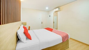A neatly made bed with white and red bedding, a wooden headboard, and a wooden floor. - Hotel O Tanjung Duren Near Mall Citraland (Jakarta)