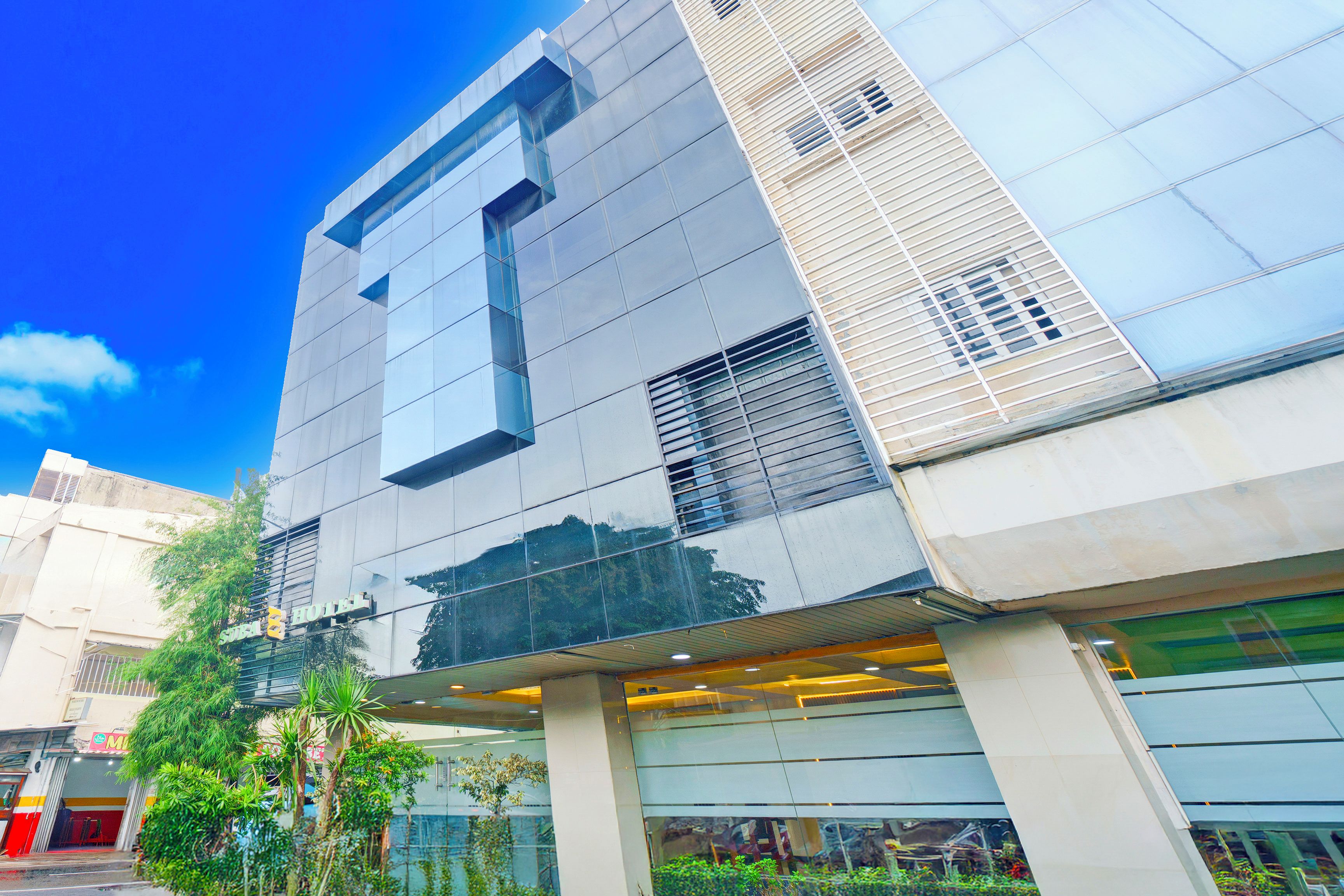 A modern building with a glass facade, large windows, and a visible entrance.