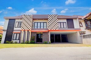 Un hotel moderno con fachada a cuadros, entrada cubierta y cielo despejado.